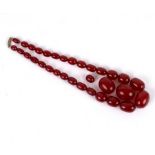 A single row of graduated cherry amber beads, and two loose cherry amber beads,
