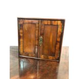 A George III mahogany cabinet enclosed by a pair of doors,