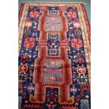 An Ardabil rug with navy ground, the geometric floral field decorated animals,