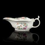 A Worcester low-footed sauceboat, circa 1753, the handle with a curled thumb rest,