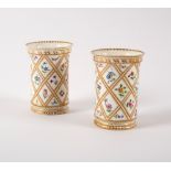 A pair of 19th Century porcelain spill vases, painted flowers on a trellis,