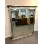 A large modern overmantel mirror with silver painted frame and bevelled plate,