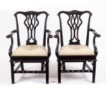 A pair of Chippendale style open armchairs with carved cresting rails, pierced upright splats,