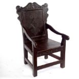 A carved oak panel back armchair incorporating 17th Century elements,