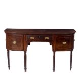 A Regency mahogany breakfront sideboard, fitted three drawers on reeded taper legs,