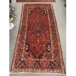 A Hamadan carpet, the navy ground with central geometric medallion to a multiple border,