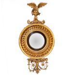 A Regency convex mirror, the giltwood ball studded frame with eagle surmount,