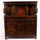 A 17th Century style oak court cupboard, the panel doors inlaid birds and flowers,