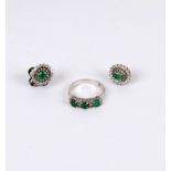 An emerald and diamond ring, the three oval emeralds interspersed by small diamonds,
