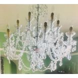A twelve-branch cut glass chandelier with S-scroll arms hung cut glass drops,
