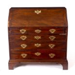 A George III mahogany bureau, the fall enclosing a fitted interior over four long drawers,