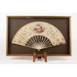 A Regency fan with painted oval vignette of a couple seated in a garden landscape,