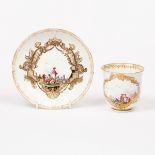 A Meissen cup and a saucer decorated harbour scenes within gilt cartouches,