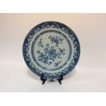 An early 19th Century blue and white saucer dish painted chrysanthemums and other flowers within a