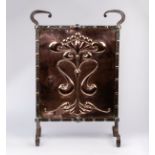 An Arts & Crafts copper firescreen/embossed a central anthemion motif,