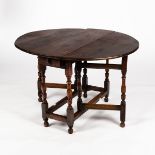 An oak gateleg table of 17th Century style, on baluster turned legs united by square stretchers,