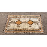 A mid-20th Century rug/design of twin diapers on a cream ground within figured borders,