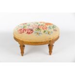 A Victorian oval footstool on tapered fluted legs,