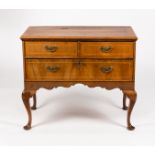 A walnut chest of one long and two short drawers, on cabriole legs,