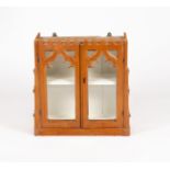 A Victorian pitch pine hanging cupboard of Gothic design, with castellated top,