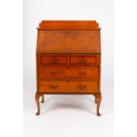 An Edwardian satinwood bureau crossbanded and fitted two long and two short drawers,