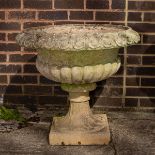 A large reconstituted stone garden vase with reeded base, 63.