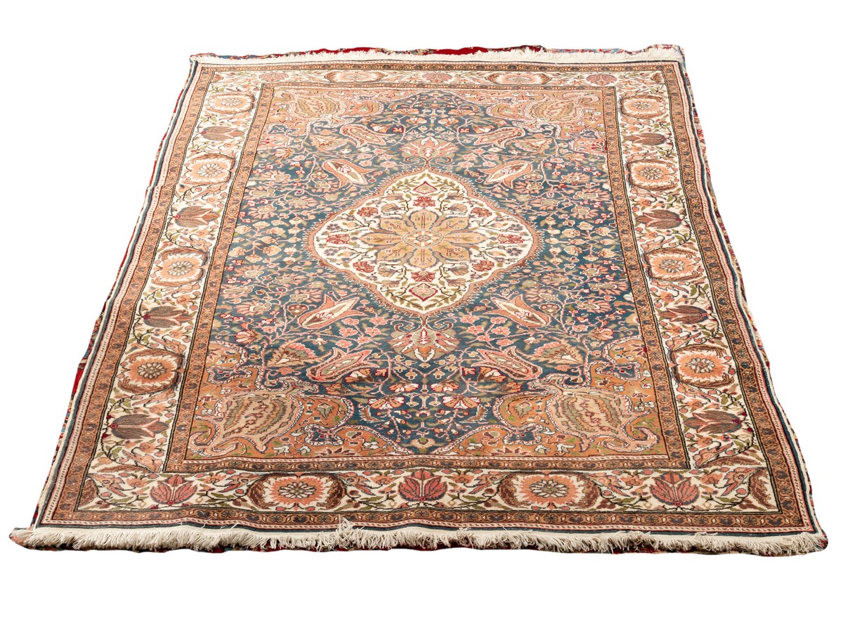 An Eastern rug with central floral medallion on a blue multi-figured ground,