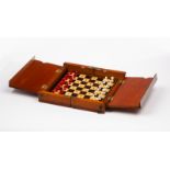 A travelling chess set complete with thirty-two white and red stained ivory pieces all 1.