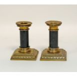 A pair of brass candlesticks with serpentine columns,