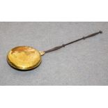 A Charles II brass warming pan, with engraved decoration and silhouette baluster handle,