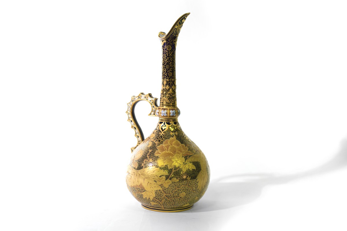 A Derby Crown porcelain ewer with a slender neck and heavily decorated in gilt,