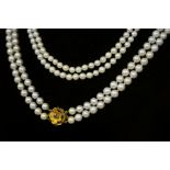 A cultured pearl two-row necklace, with gem set flowerhead clasp in 9ct yellow gold marked H&T,