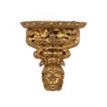 A Florentine gilt wall bracket, the shelf above pierced foliate support with mask below, 29.