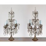A pair of table candelabra with four candle sconces and three tiers of branches hung lustre drops,