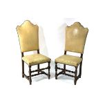 A pair of arch back chairs with leather upholstery,