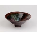 A stoneware footed bowl, Margaret Frith (born 1943), with tenmoku, wax brushwork,