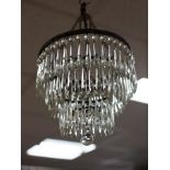 A small glass light fitting, the four graduated circular tiers hung with prismatic drops,