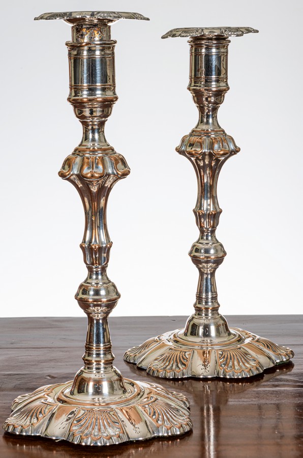 A pair of early George III Sheffield plate candlesticks, with lobed and shell decorated drip trays