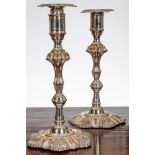 A pair of early George III Sheffield plate candlesticks, with lobed and shell decorated drip trays