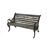 A slatted garden bench, the iron end supports decorated with eagles,