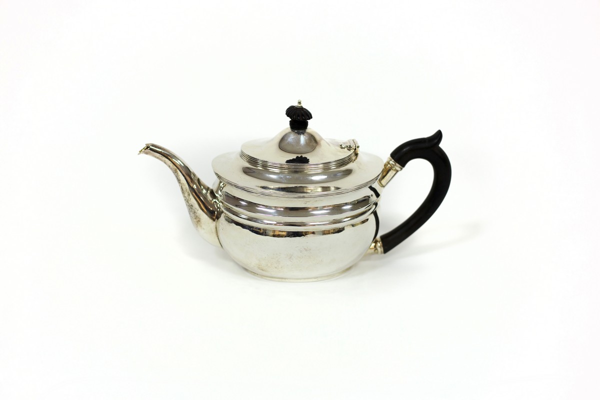 A silver teapot, London 1911, of oval shape with ebonised finial and handle,