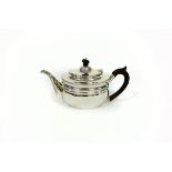 A silver teapot, London 1911, of oval shape with ebonised finial and handle,