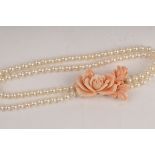 A two-row cultured pearl necklace with carved coral clasp,