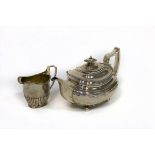 A George III silver teapot, SH, London 1815 and a cream jug with half-ribbed decoration,