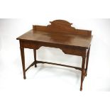 An Edwardian satinwood kneehole dressing table, cross banded with shaped backboard,