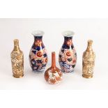 A pair of Japanese satsuma bottle vases, Meiji period, decorated overlapping reserves of figures,