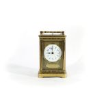 A Victorian gilt brass cased carriage clock, with circular enamel dial and repeat mechanism, 18.