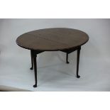 A George III mahogany oval two-flap table on cabriole legs with pad feet,