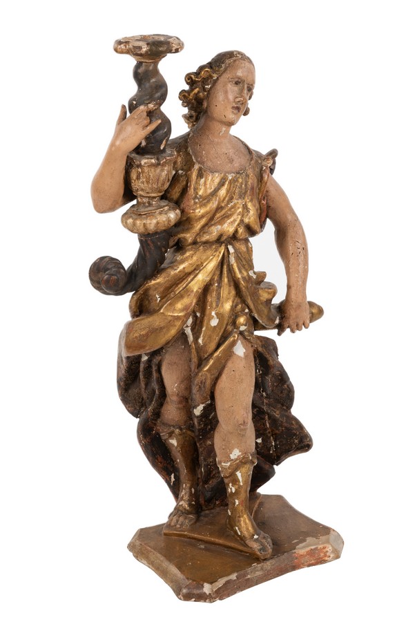 A Spanish carved figural candle stand modelled as a figure holding a twisted candle sconce,