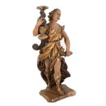 A Spanish carved figural candle stand modelled as a figure holding a twisted candle sconce,